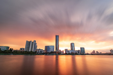 Fototapeta na wymiar Beautiful cloudy sunset at the city pond. Long Exposure cityscape of Yekaterinburg, Russia with skyscrappers reflecting in water