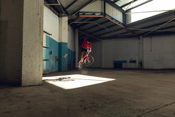 BMX rider in an empty warehouse jumping