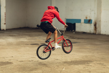BMX rider in an empty warehouse jumping
