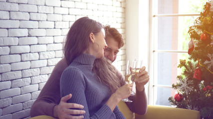 Lovely white couple hugging drinking champagne on Christmas day