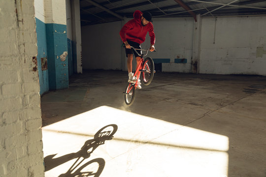 BMX rider in an empty warehouse jumping