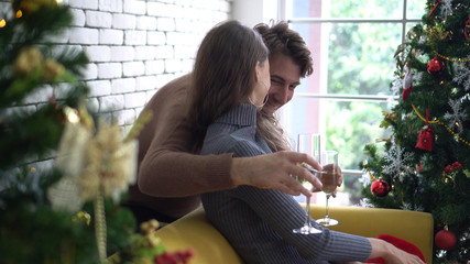 Lovely white couple hugging drinking champagne on Christmas day