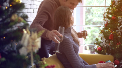Lovely white couple hugging drinking champagne on Christmas day