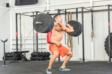 Fototapeta na wymiar Bare chested man weightlifting barbell in gym