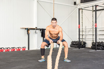 Fototapeta na wymiar Men with battle ropes exercise in the fitness gym