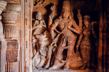 Sculptures of Shiva lord inside of 6th century Hindu temple in India. Architecture with carved walls in Badami - obrazy, fototapety, plakaty