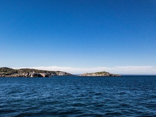 Fototapeta na wymiar Contrast beautiful scene with green island between bay of sea and blue sky