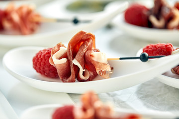 Delicious canapes hamon with raspberries. Concept of food, restaurant, catering, menu.