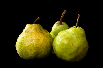 Fototapeta na wymiar Three fresh, organic, ripe Green Anjou pears with the stems and water drops, isoated on a black background