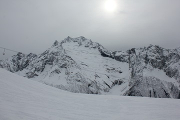 Fototapeta na wymiar panoramic views of the snow-capped mountains and the ski run