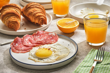 Continental breakfast. Fried eggs and sausage with croissants and orange juice.