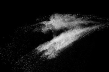 Freeze motion of white color powder exploding on dark background. 