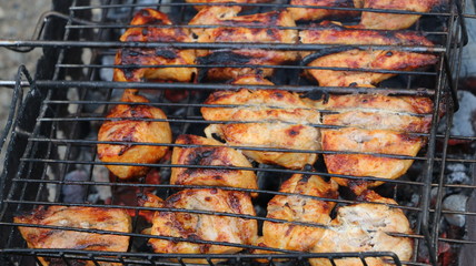 cooking meat on hot coals and fire in the barbecue, on the grill. hot kebabs, and pork barbecue. Fresh hot juicy grill.
