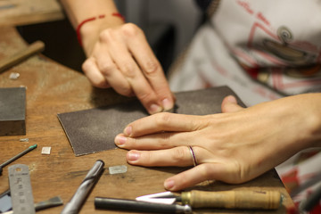 Fototapeta na wymiar A jewelry master is working to create a silver ring