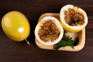 Passion fruit.Used as a natural soothing.Seeds in half the fruit, top view.Exfoliating.Dark wood background.