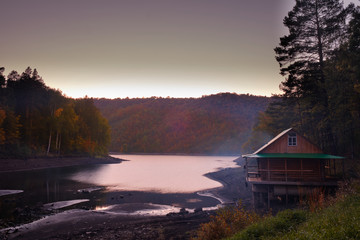 House hunting on the shore of the lake at sunset . Log home, lake sunset