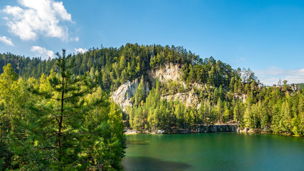 Lake and ancient pines growing between them located in rock city Adrspach, National Park of Adrspach, Czech Republic.