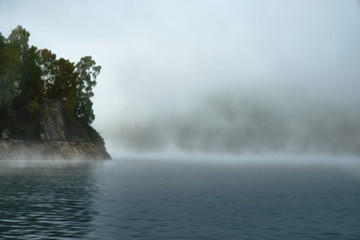 Foggy landscape in autumn on a lake in Norway in the mountains.