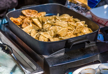 Chinese Potstickers Cooking in a Pan at a Food Market