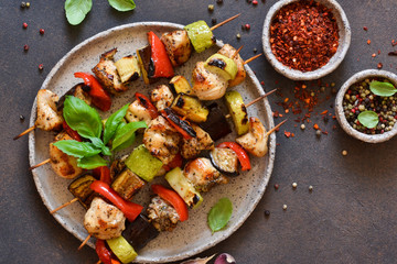 Barbecue of chicken on skewers with vegetables on stone background. Picnic.