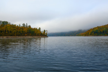 Foggy landscape in autumn on a lake in Norway in the mountains.