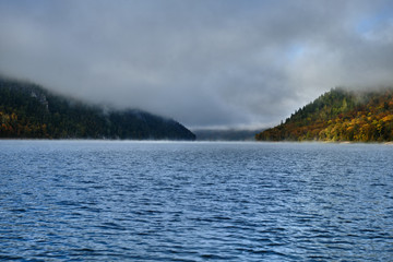 Foggy landscape in autumn on a lake in Norway in the mountains.