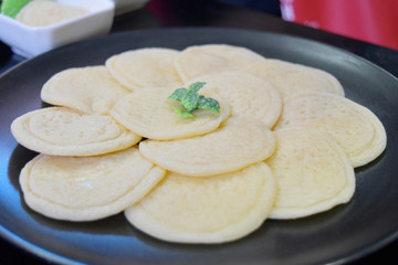 Sweet pancakes made from flour with sweet sauce on white plate.