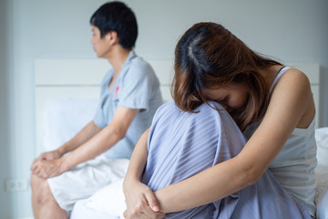 Fototapeta premium Couples are bored, stressed, stressed, and irritated after an argument. Sitting on each side of the bed