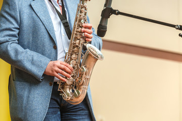 A man in a suit plays the saxophone