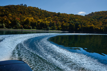 Wake from the boat on autumn lake in Sweden. Trace from a boat on the water
