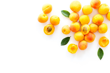 Fruit background with apricots and leaves on white background top view space for text