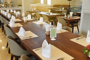 Modern interior of restaurant. Wooden furniture design and empty tables set ready for breakfast,  dinner.