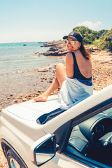 woman laying at car hood with view of sea summer beach