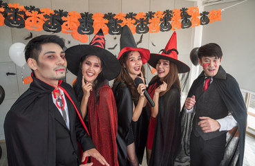 Group of young people singing a song with joy and happy for celebrate autumn Halloween party