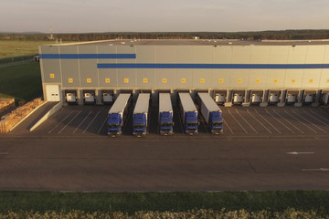 large warehouse complex with parked trucks awaiting loading. Logistics center, warehouse terminal