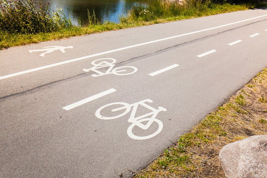 Fu&szlig;g&auml;nger und Fahrradspur auf Stra&szlig;e. Pedestrian and bicycle lane on cement road.
