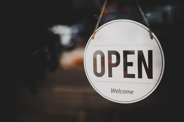 Open sign hanging front of cafe with colorful bokeh light abstract background.