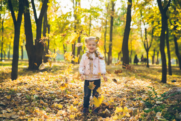 mather with little toddle daughter playing in autumn city public park