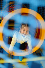 Cute little girl playing in a children's entertainment center in the game maze.