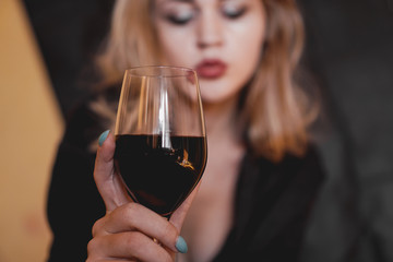 Beautiful woman with glass red wine - selective focus.