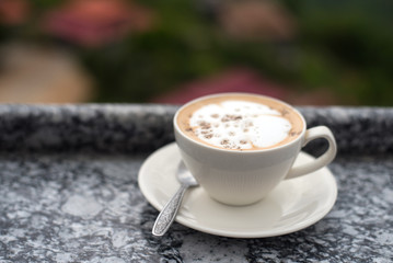 A cup of coffee put on table with mountains background