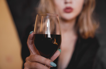 Beautiful woman with glass red wine - selective focus.