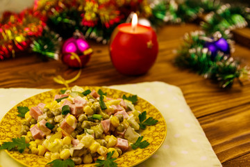Tasty festive salad, Christmas decor and candle on wooden table