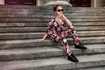 Fashionable stylish beautiful young model in summer autumn floral clothes posing in the street - Image
