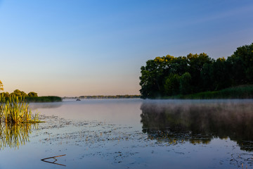Fog above the water surface. Sunrise at river