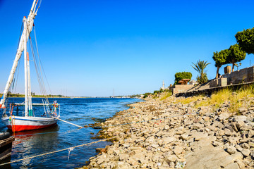 Traditional egyptian vessel felucca moored near the bank of Nile river in Luxor, Egypt