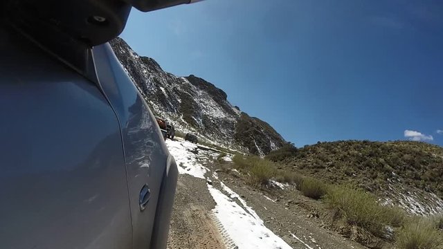 Camara a bordo de camioneta 4x4 circulando por caminos de monta&ntilde;a de la cordillera de los andes con nieve, en la patagonia argentina