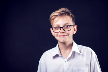 A portrait of a smilling boy on the black background