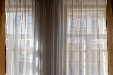 window view with tulle and curtains on the building opposite