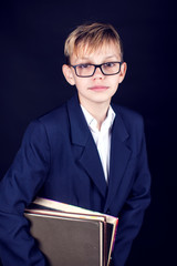 A boy holds a book. Pupil and education concept